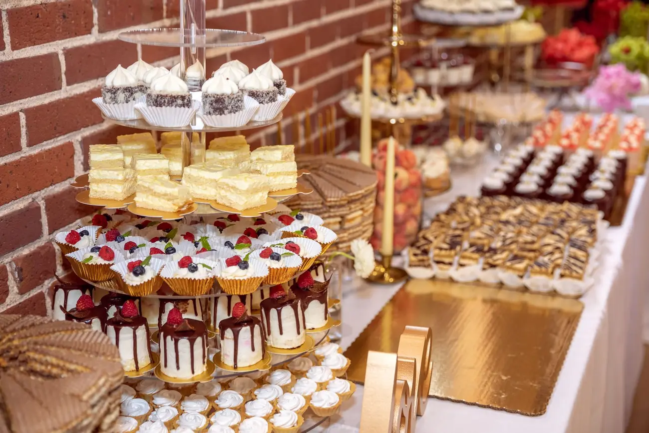 A full dessert table with small cakes and pastries