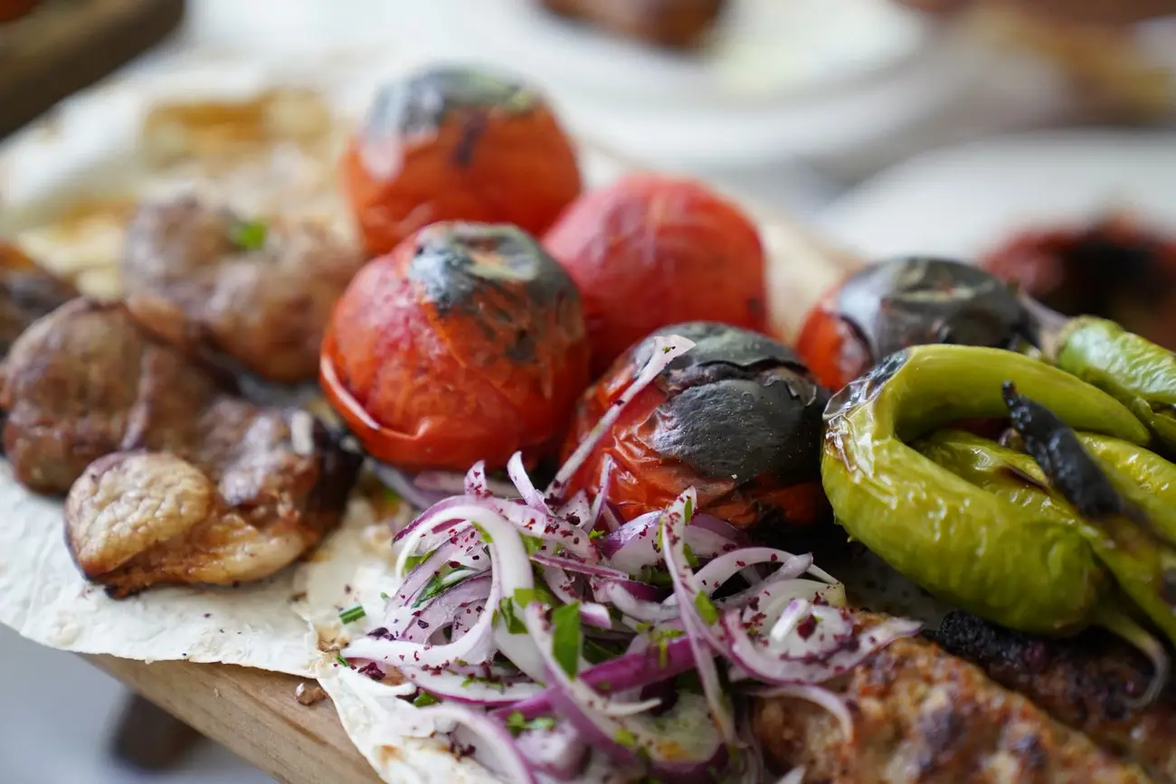 Charred tomatoes, peppers and grilled food served together