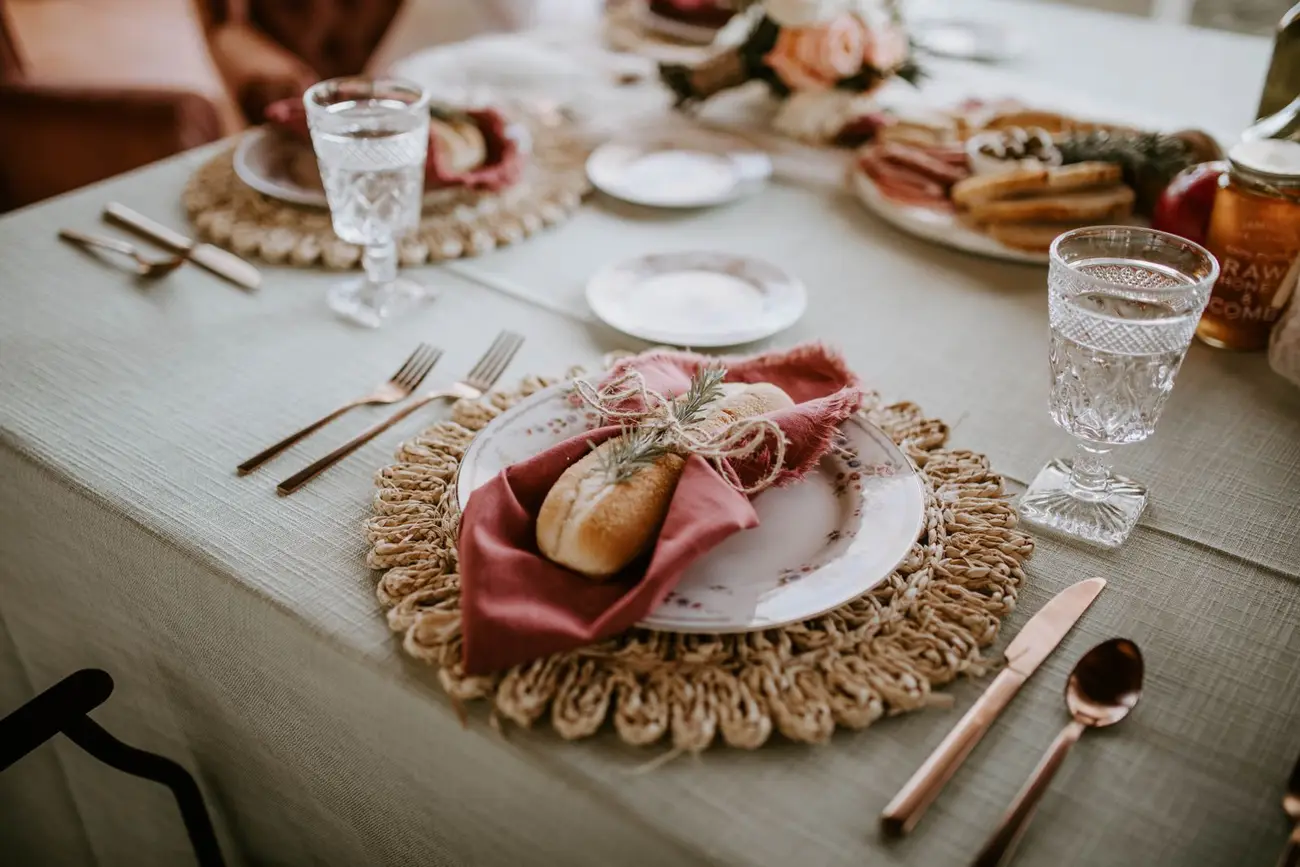 An inviting place setting with bread and a rose-coloured napkin