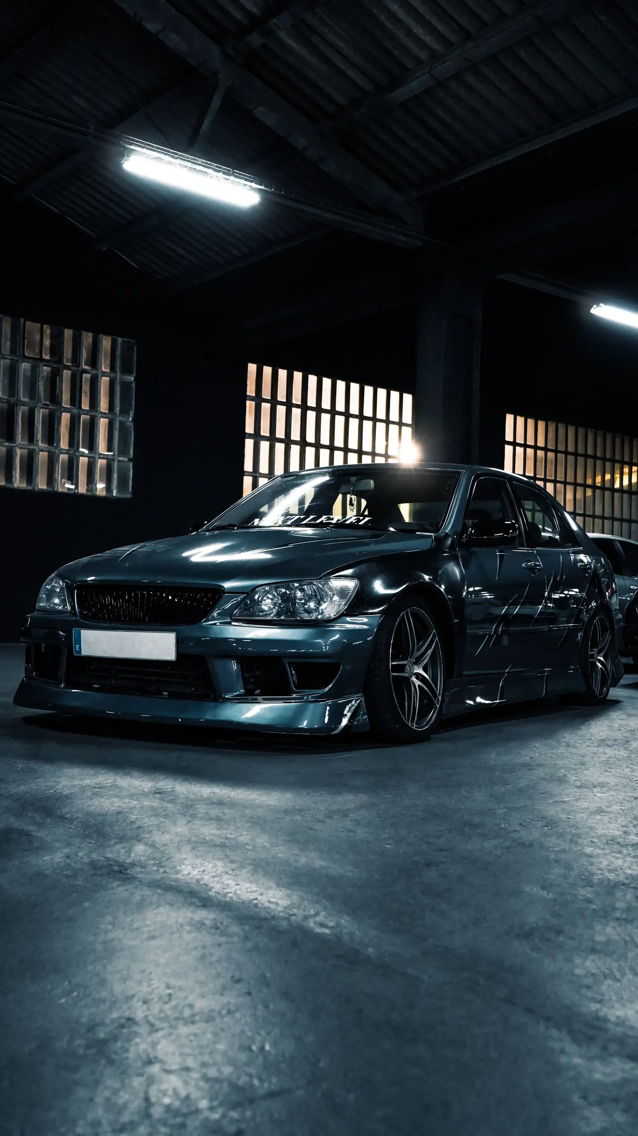 Glossy dark saloon beneath workshop lights