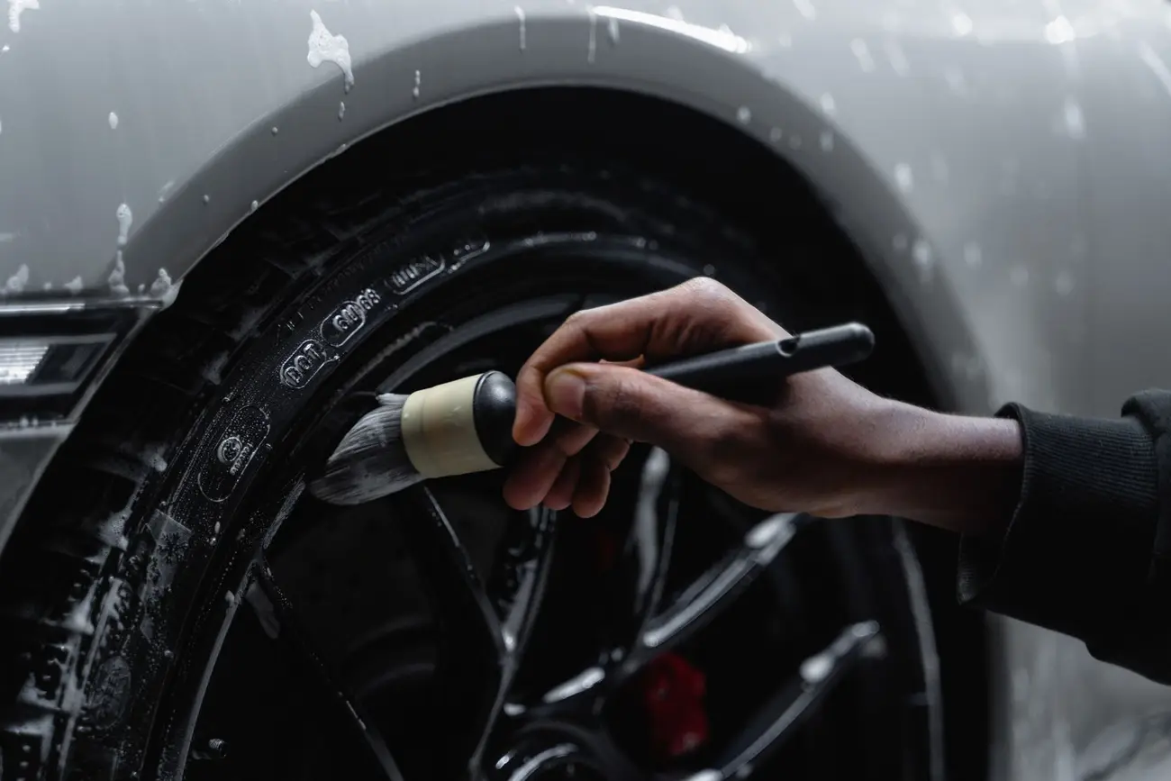 Detailer brushing a car wheel