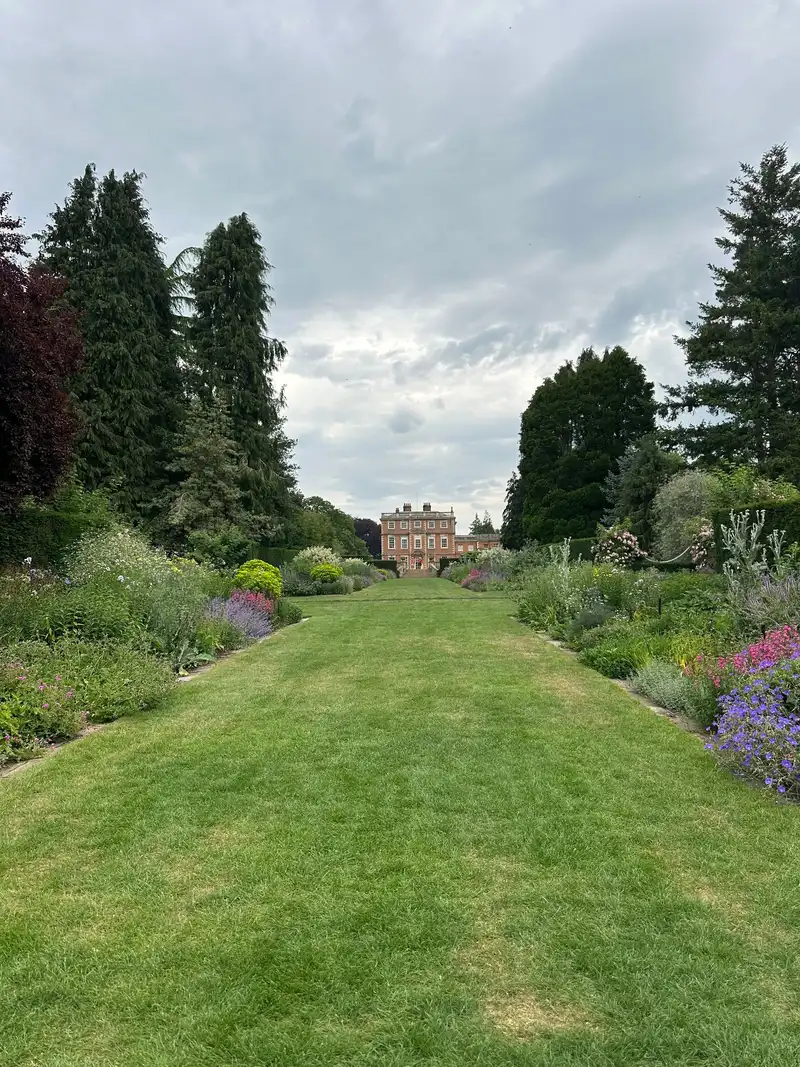 Long lawn and generous planting borders leading towards a country house in Ripon