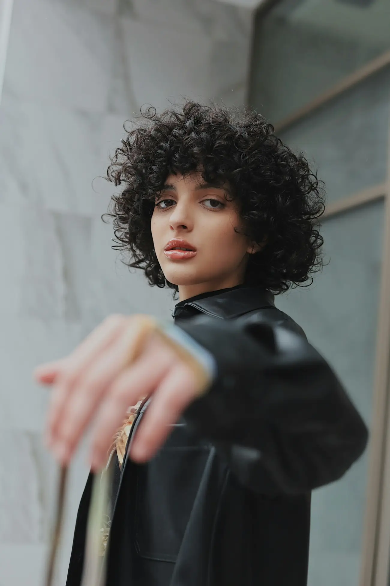 Editorial portrait with a sculptural dark curly cut